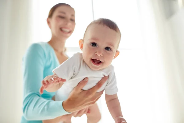 Feliz joven madre con pequeño bebé en casa — Foto de Stock