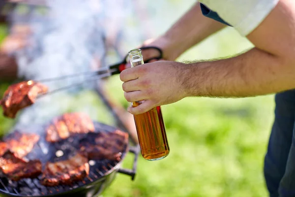 Mann kocht bei Sommerfest Fleisch auf Grill — Stockfoto