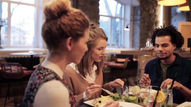 Amigos felices comiendo y bebiendo en el restaurante — Vídeo de stock