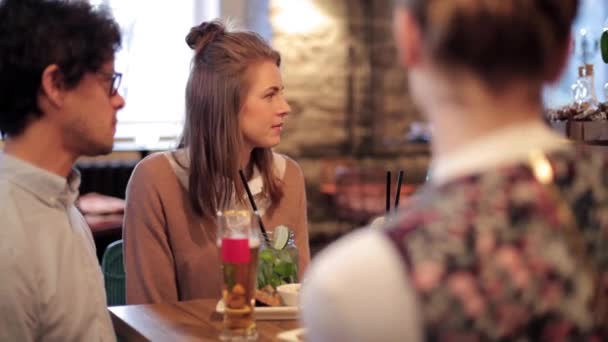 Glückliche Freunde essen und trinken an der Bar oder im Café — Stockvideo