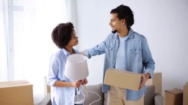 Feliz pareja con cosas mudándose a un nuevo hogar — Vídeo de stock