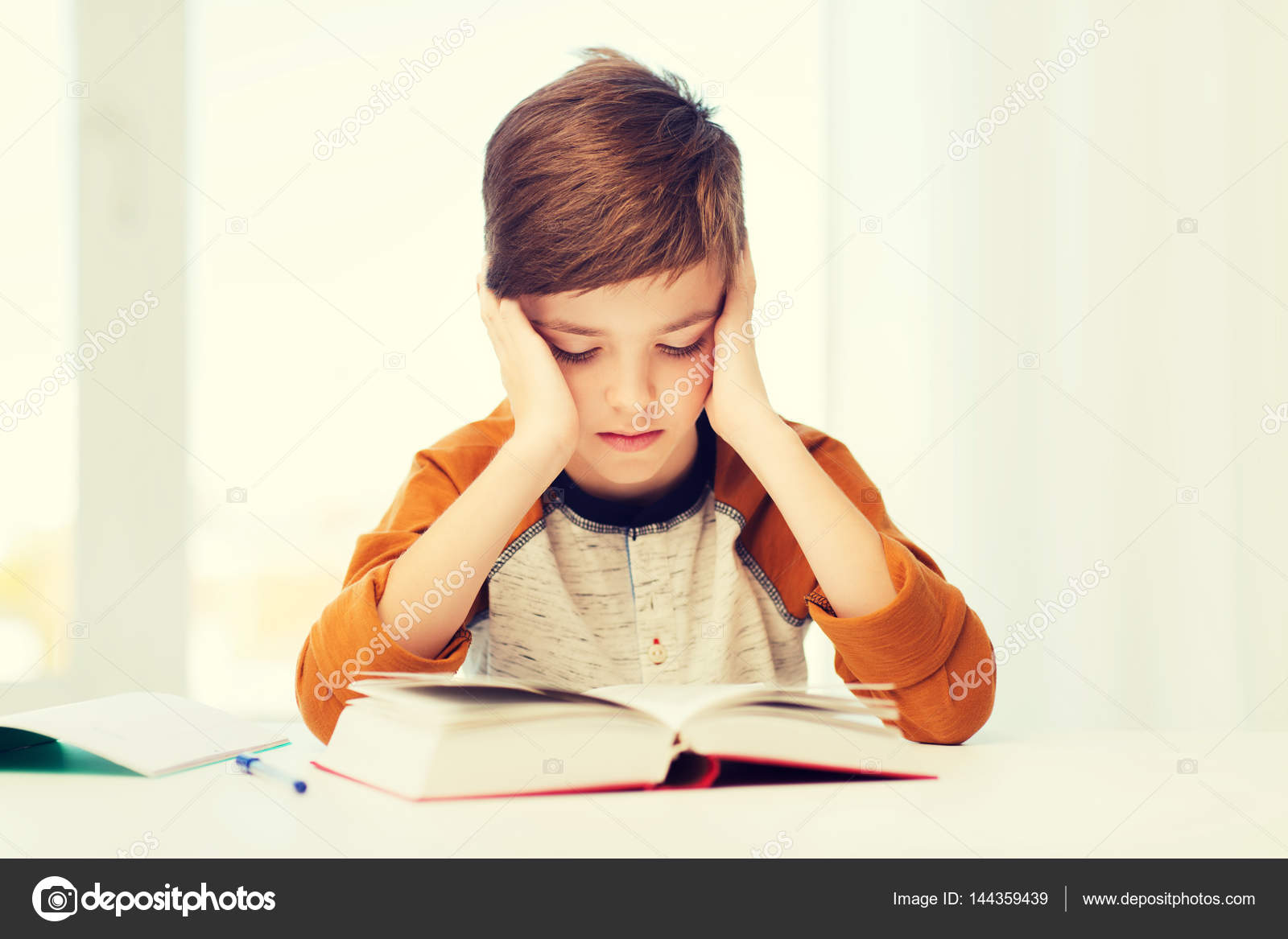 Estudiante niño leyendo libro o libro de texto en casa ...