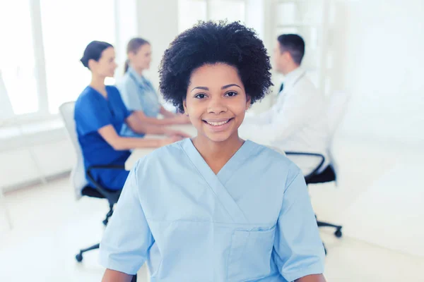 Doctor or nurse over group of medics at hospital — Stock Photo, Image