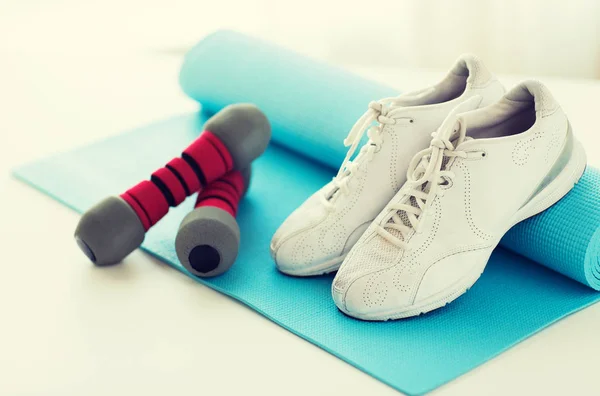 Primer plano de zapatillas de deporte, mancuernas y alfombra deportiva — Foto de Stock