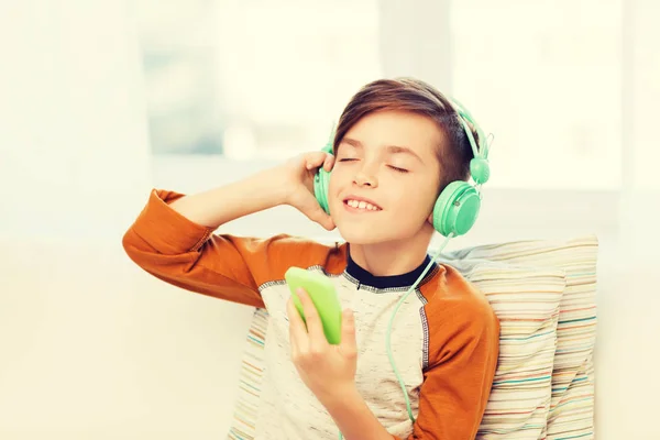Happy boy with smartphone and headphones at home — Stock Photo, Image