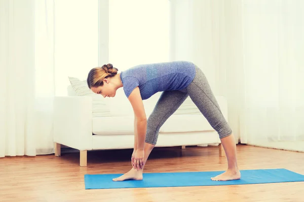 Vrouw maken yoga intens stretch pose op mat — Stockfoto