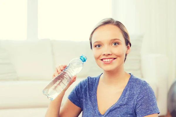Femme heureuse avec bouteille d'eau à la maison — Photo