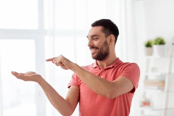 Homem feliz segurando algo imaginário em casa — Fotografia de Stock