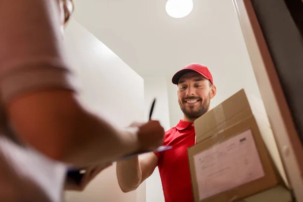 Repartidor y cliente con cajas de paquetes en casa — Foto de Stock