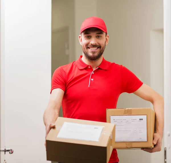 Homem de entrega com caixas de encomendas na porta do cliente — Fotografia de Stock