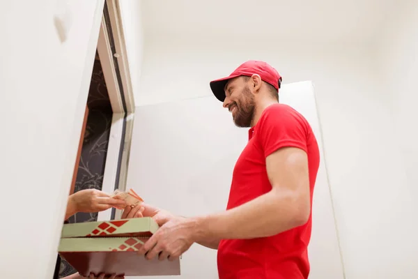 Homem entregando pizza ao cliente e levando dinheiro — Fotografia de Stock