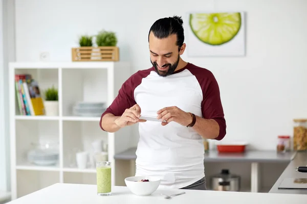 Hombre fotografiando el desayuno por teléfono inteligente en casa —  Fotos de Stock