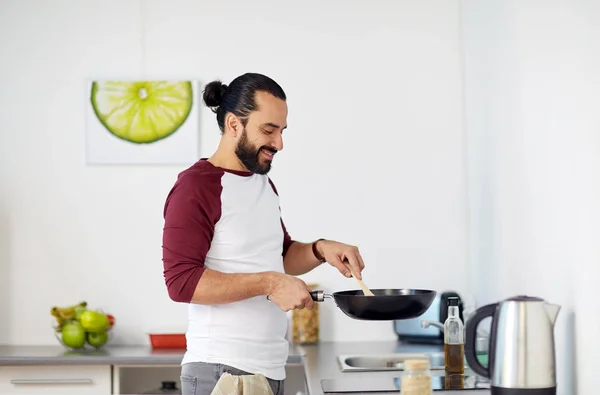 Hombre con sartén cocina comida en casa cocina —  Fotos de Stock