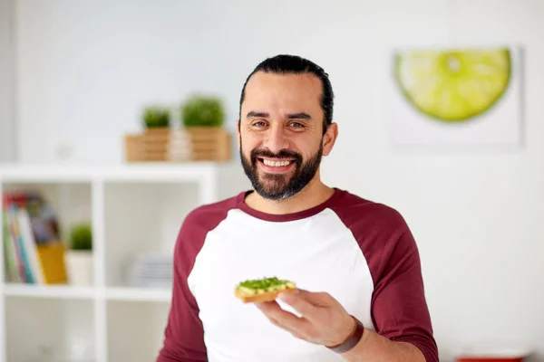 Uomo mangiare panini avocado a casa cucina — Foto Stock