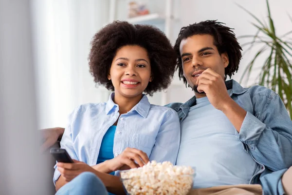 Sorrindo casal com pipocas assistindo tv em casa — Fotografia de Stock