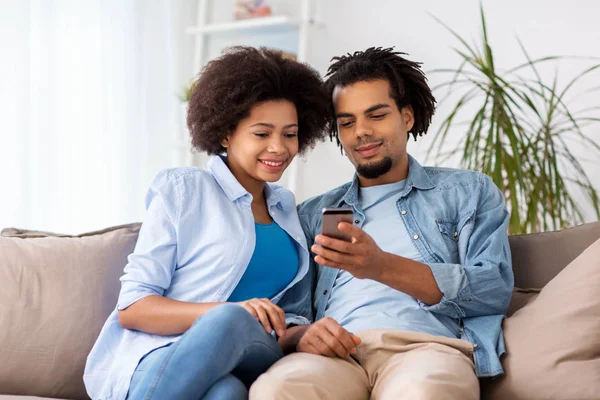 Casal feliz com smartphones em casa — Fotografia de Stock