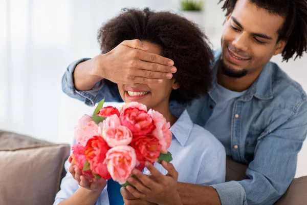 Happy couple with bunch of flowers at home — Stock Photo, Image
