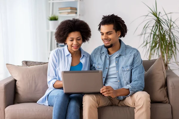 Sonriente feliz pareja con portátil en casa — Foto de Stock