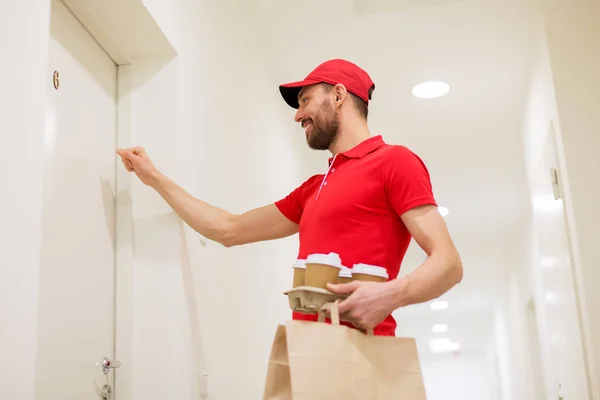 Entrega homem com café e comida batendo na porta Fotos De Bancos De Imagens