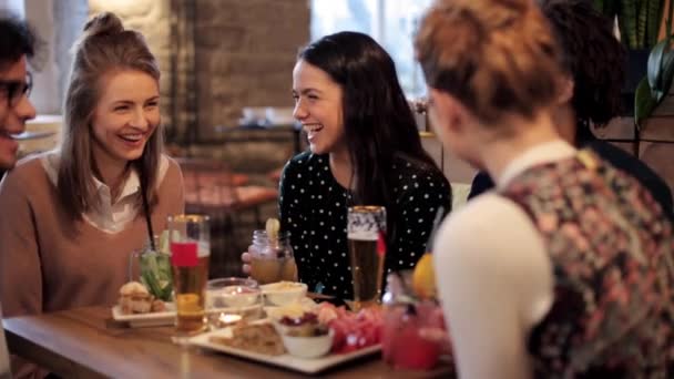 Glada vänner spottar drinkar i baren — Stockvideo