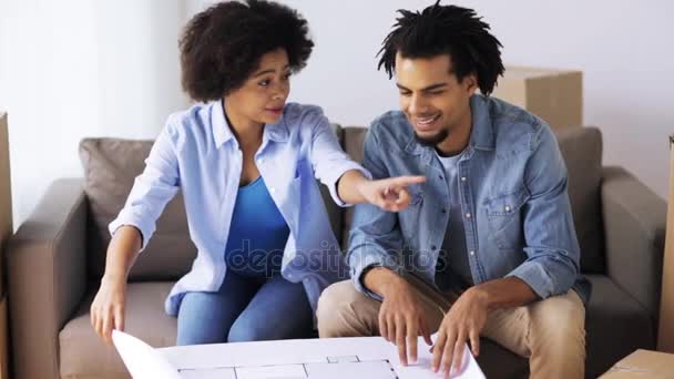 Happy couple with blueprint and boxes at new home — Stock Video