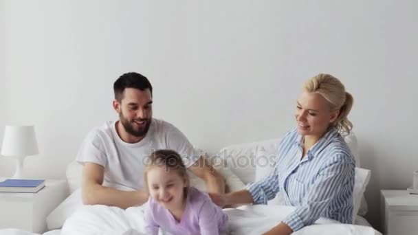 Щаслива сім'я розважається в ліжку вдома — стокове відео