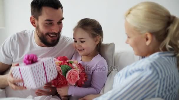 Семья дарит цветы и подарок матери в постели — стоковое видео