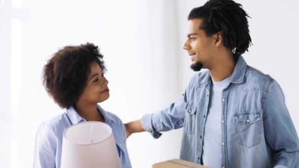 Feliz pareja con cosas mudándose a un nuevo hogar — Vídeo de stock