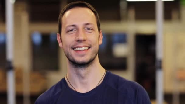 Ευτυχισμένος χαμογελαστός νεαρός άνδρας στο γυμναστήριο — Αρχείο Βίντεο