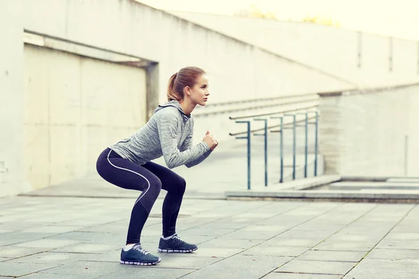 Mujer haciendo sentadillas y haciendo ejercicio al aire libre — Foto de Stock