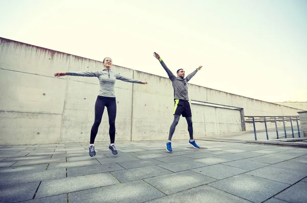 Feliz hombre y mujer saltando al aire libre — Foto de Stock