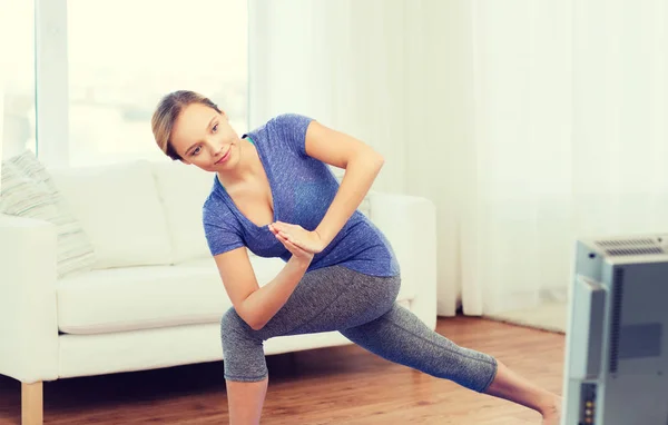 Mujer haciendo yoga bajo ángulo embestida pose en la estera — Foto de Stock