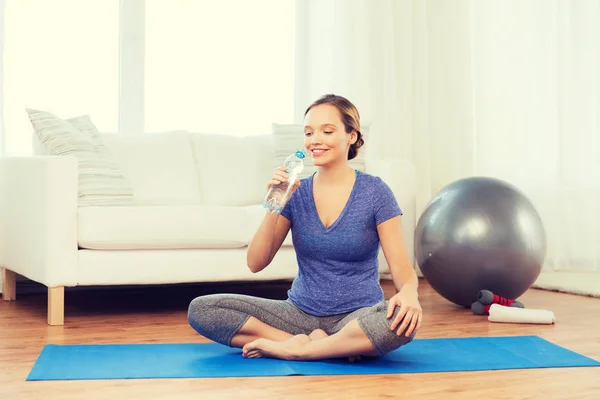 Su şişesi evde egzersiz ile mutlu kadın — Stok fotoğraf
