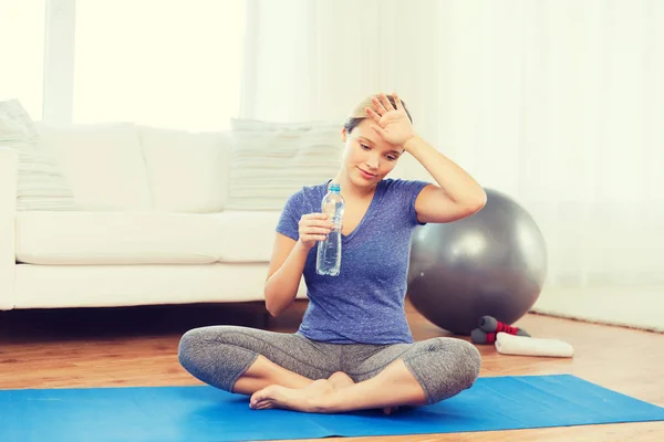 Mujer cansada beber agua después del entrenamiento en casa —  Fotos de Stock