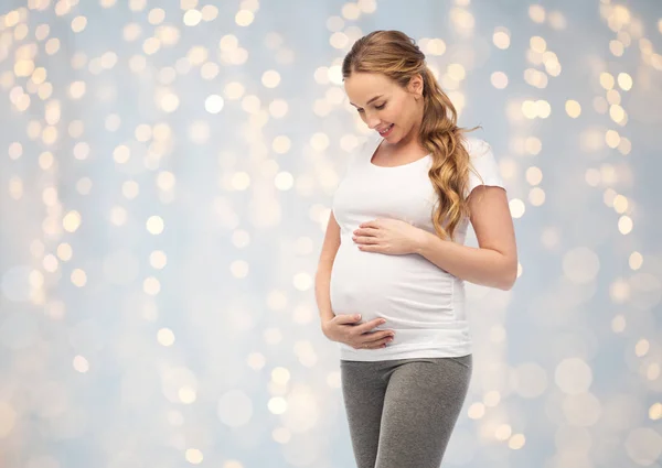 Mulher grávida feliz tocando sua barriga grande — Fotografia de Stock