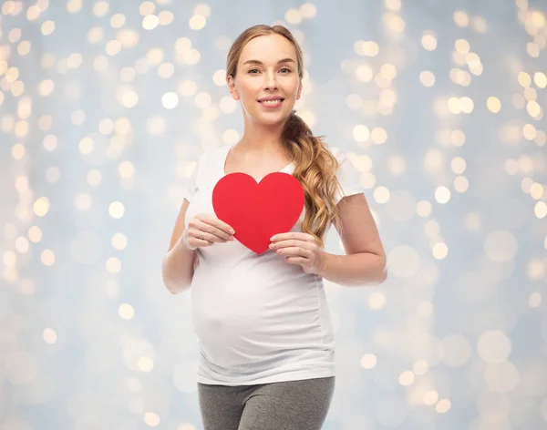 Glückliche schwangere Frau mit rotem Herzen — Stockfoto