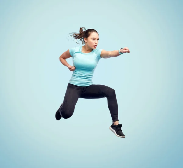 Gelukkig sportieve jonge vrouw springen in de strijd tegen pose — Stockfoto