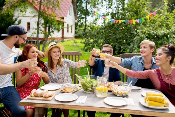 Glada vänner med fest på summer garden — Stockfoto