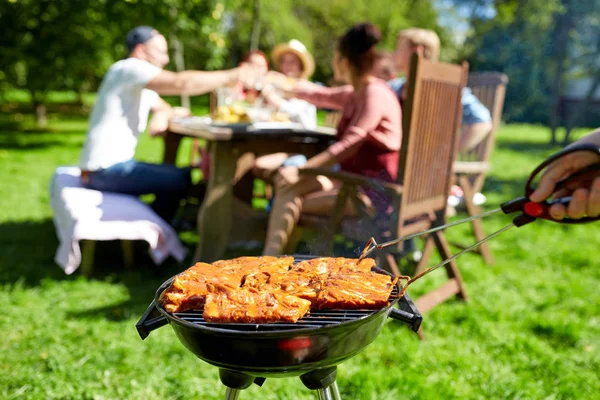 Człowiek, gotowanie mięsa na grilla na summer party — Zdjęcie stockowe
