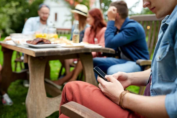Homem com smartphone e amigos na festa de verão — Fotografia de Stock