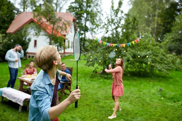 Szczęśliwy przyjaciele grać badminton w letni ogród — Zdjęcie stockowe