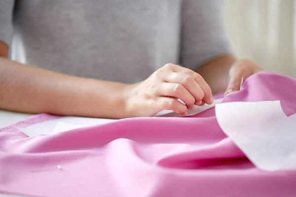 Kvinna med stift sy papper mönster till tyg — Stockfoto