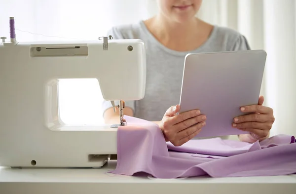 Sastre con máquina de coser, tableta pc y tela —  Fotos de Stock