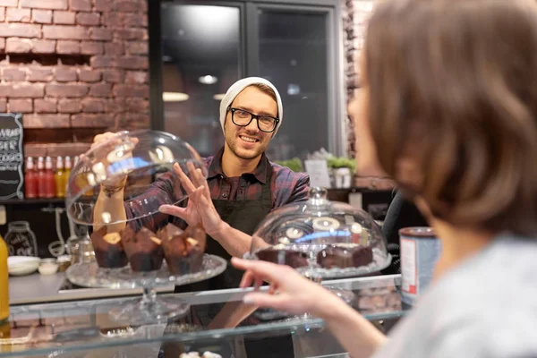 Homme ou barman avec des gâteaux servant le client au café — Photo