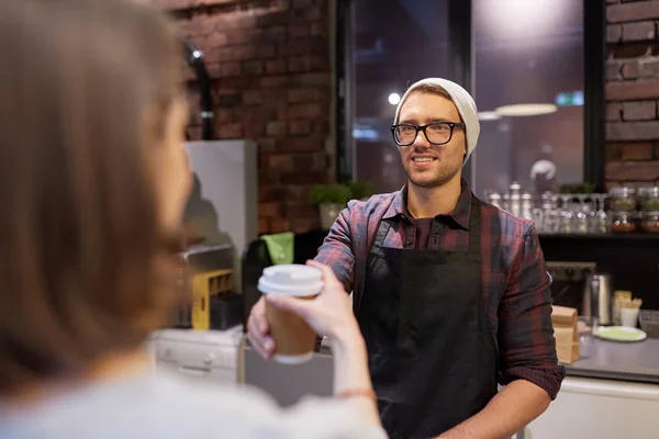 Vendedor dando taza de café a la mujer cliente en la cafetería —  Fotos de Stock