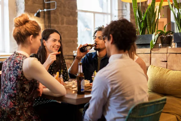 Happy přátelé, jídlo a pití v baru nebo kavárně — Stock fotografie