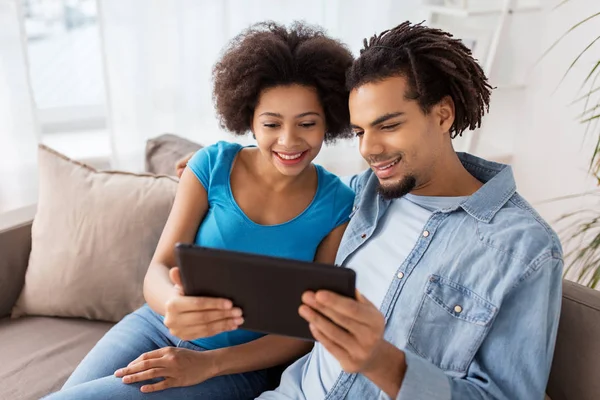 Sorrindo casal feliz com tablet pc em casa — Fotografia de Stock