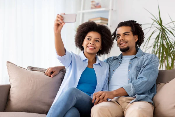 幸福的情侣，与智能手机在家里以自拍照 — 图库照片
