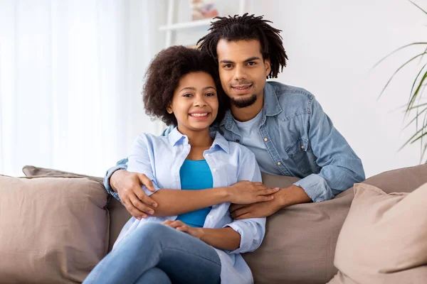 Couple heureux assis sur le canapé et câlin à la maison — Photo