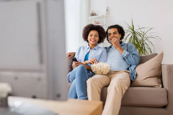 Sonriente pareja con palomitas de maíz viendo tv en casa — Foto de Stock